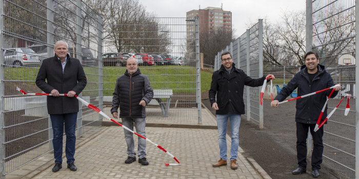 Foto: Eröffnung der Freifläche Körnerstraße © Stadtverwaltung Erfurt vier Männer stehen vor einer Grünfläche und halten ein Absperrband in der Hand